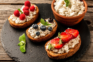 Strawberry bruschetta with cottage cheese. Homemade healthy toast, Fruit sweet sandwich with ripe summer berries. Food recipe background. Close up