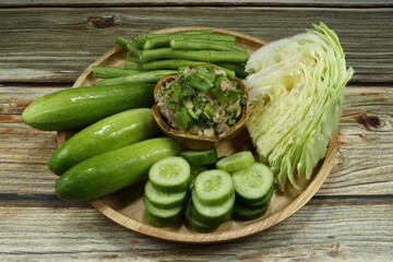 Traditional fish meat paste seasoning with chilly, shallot, garlic, lime and parsley serving with fresh cucumber, green bean and cabbage. Famous spicy seafood paste in Asia. Low fat and diet menu.