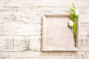 White flowers with square tray on white wooden background. Mother's and Valentine's day greeting card concept. Top view. Copy space.