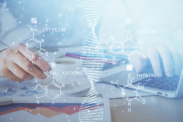 DNA hologram with businessman working on computer on background. Concept of bioengineering. Double exposure.
