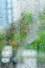 rainy droplets on a window glass. transparent surface. drops on window shield in a rainy days  in a city. stormy weather.  rainy season. stay home.