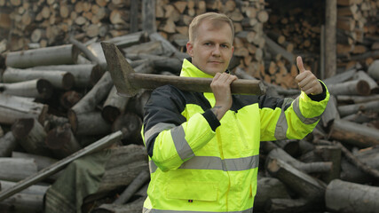 Lumberjack in reflective jacket. Man woodcutter with big axe. Sawn logs, firewood background