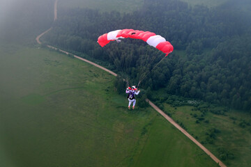Skydiving. A parachute is in the sky.