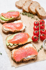 Rye bread toasts with avocado, smoked salmon and cream cheese.