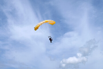 Skydiving. A parachute is in the sky.