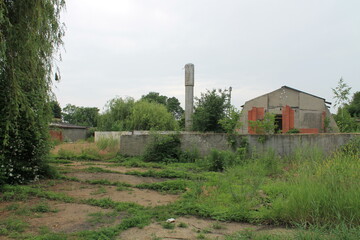 Fototapeta na wymiar Abandoned hangars and buildings in greenery