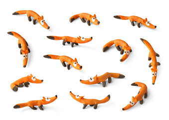 Set of cute foxs made of plasticine isolated on white background. Handmade orange fox figurines of...