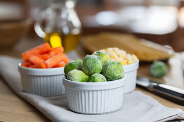 Frozen vegetables such as baby carrot and and Brussels sprouts in the bowls on the kitchen table