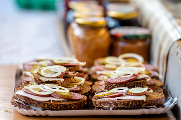 Bread with meat, sausage and onions on a tray in an outdoor cafe. Quick snacks., selective focus