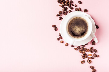 White cup of coffee with coffee beans, candy sugar and spices on pink background with copy space for text. Top view.