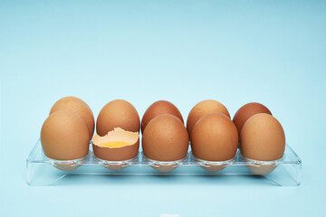 Chicken eggs in an egg holder. Full tray of eggs. Half an egg, egg yolk, shell. Food, protein in foods.