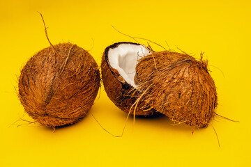 Parts of coconut on a colored background. Close up. Fresh ripe coconut broken into pieces.