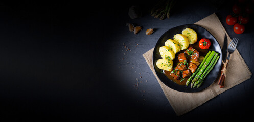 dumplings with beef goulash and green asparagus