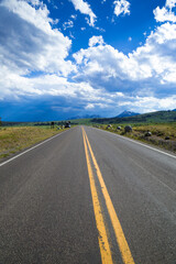 Straight road under cloudy sky in Yellowstone