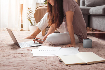 Obraz premium Young woman using laptop for work in living room at home