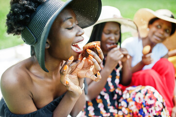 Group of african american girls celebrating birthday party and eat muffins outdoor with decor.