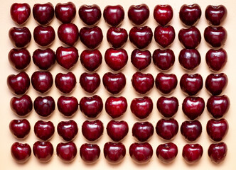 Fresh sweet cherry on yellow background. Creative art pattern wallpaper.