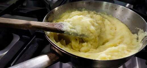 Mashed potatoes in a hot frying pan on the stove and served dinner in the kitchen
