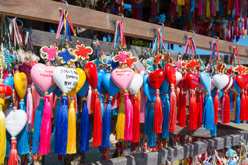 The multitude of colorful hearts with tassels for wishes and names of visitors on the stand of Yun...