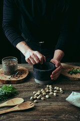 Close-up of hands preparing food in the kitchen. Cozy black background of home kitchen. The concept of healthy eating.