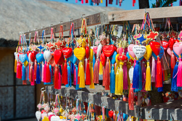 The multitude of colorful hearts with tassels for wishes and names of visitors on the stand of Yun...