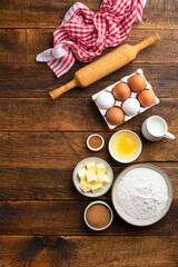 Ingredients for baking pastry, cake, cookies or bread on a wooden table background. Top view, copy space. Home baking concept