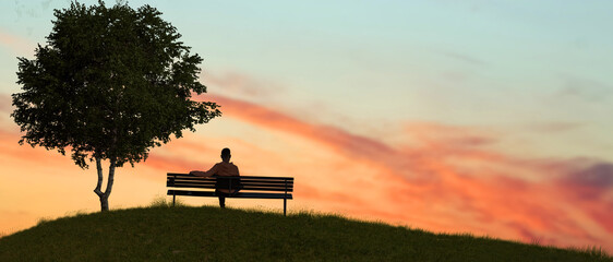 A man sitting on a bench in nature outdoor sunset. - Powered by Adobe