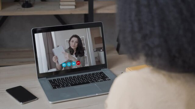 Video call. Remote work. A girl work from home. She communicate via video communication with colleagues using laptop