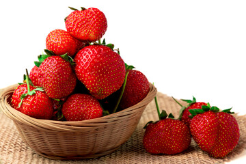 Strawberry. Close-up of sweet ripe fragrant strawberries in a basket on burlap isolated on a white background.