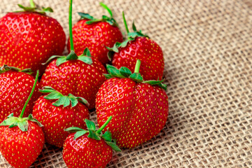 Strawberry close-up. Sweet juicy flavorful strawberries on burlap, copy space.
