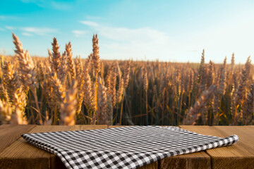 Empty wooden deck table over wheat field with sunset or sunrise. Ready for product montage