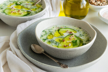 Summer refreshing cold yogurt soup, healthy meal with fresh raw vegetables and dairy ingredients