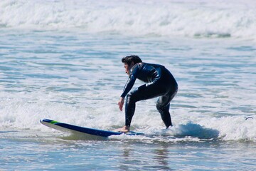 20s man surfing in CA, the US