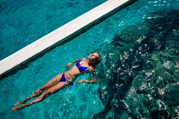 young woman in bikini swimming in water