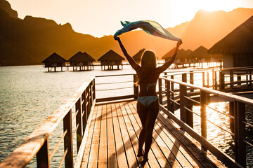 Beautiful girl posing on dock on sunset. tropical resort
