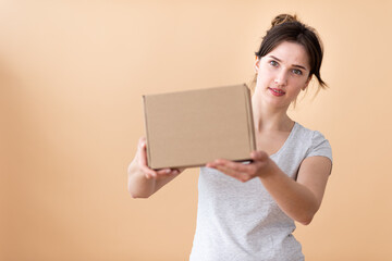 Happy girl showing craft box in her hands and smiling joyfully in the background. Box in focus with free space for text.