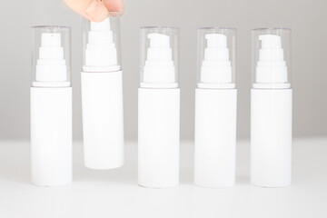 white bottles with dispenser stand on a white background. Natural Organic Spa Cosmetic Beauty Concept. Mockup Front view.