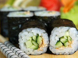 Japanese maki roll with cucumber on a wooden tray close-up © Alex