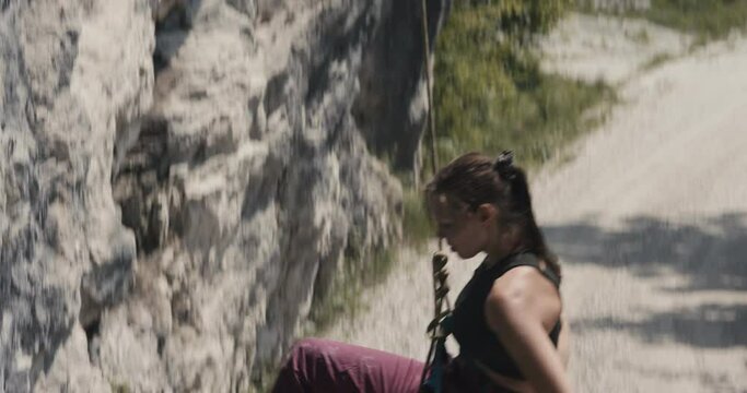 Female paralympic climber woman athlete with missing fingers on left hand finish rock climb descend rappel fist bump partner outdoors lifestyle sport in nature