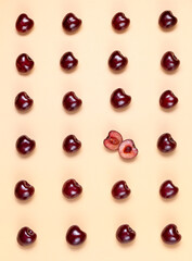 Sweet cherry on the yellow background pattern. Creative art food photo.