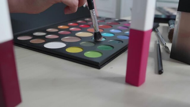 Colored eye shadows. Fashion blogger presenting makeup cosmetics at home. Influencer in the concept of social media.