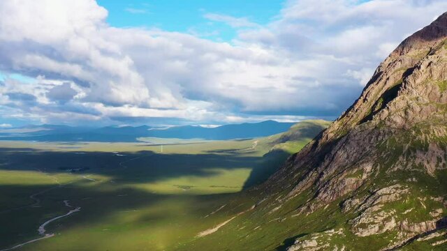 aerial footage of rannoch moor and buachaille etive mor with surrounding mountains near glencoe in the argyll and lochaber region of the highlands of scotland during a summer evening