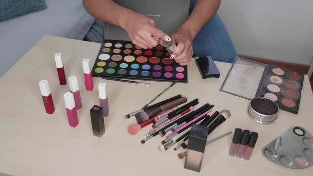 Hands holding cosmetics. Fashion blogger presenting makeup cosmetics at home. Influencer in the concept of social media.