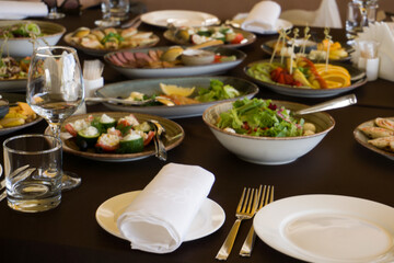 Served for a banquet table. Wine glasses with napkins, glasses and salads.
