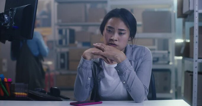 Bored young woman working in warehouse