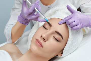 beautiful woman getting beauty facial injections into her forehead. beauty treatment and cosmetology