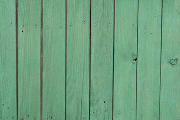 Several of planks painted in green. Fragment of the fence.