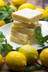 Authentic Shortcake Cake, a lot of fresh yellow lemons and mint. Morning atmospheric lighting, fashionable trendy spot soft focus. Preparation for design creative menu.