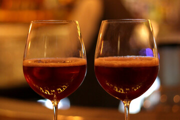 Two Goblets filled with Red Wine with fingerprints on them.