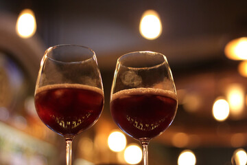 Two Goblets filled with Red Wine with fingerprints on them.